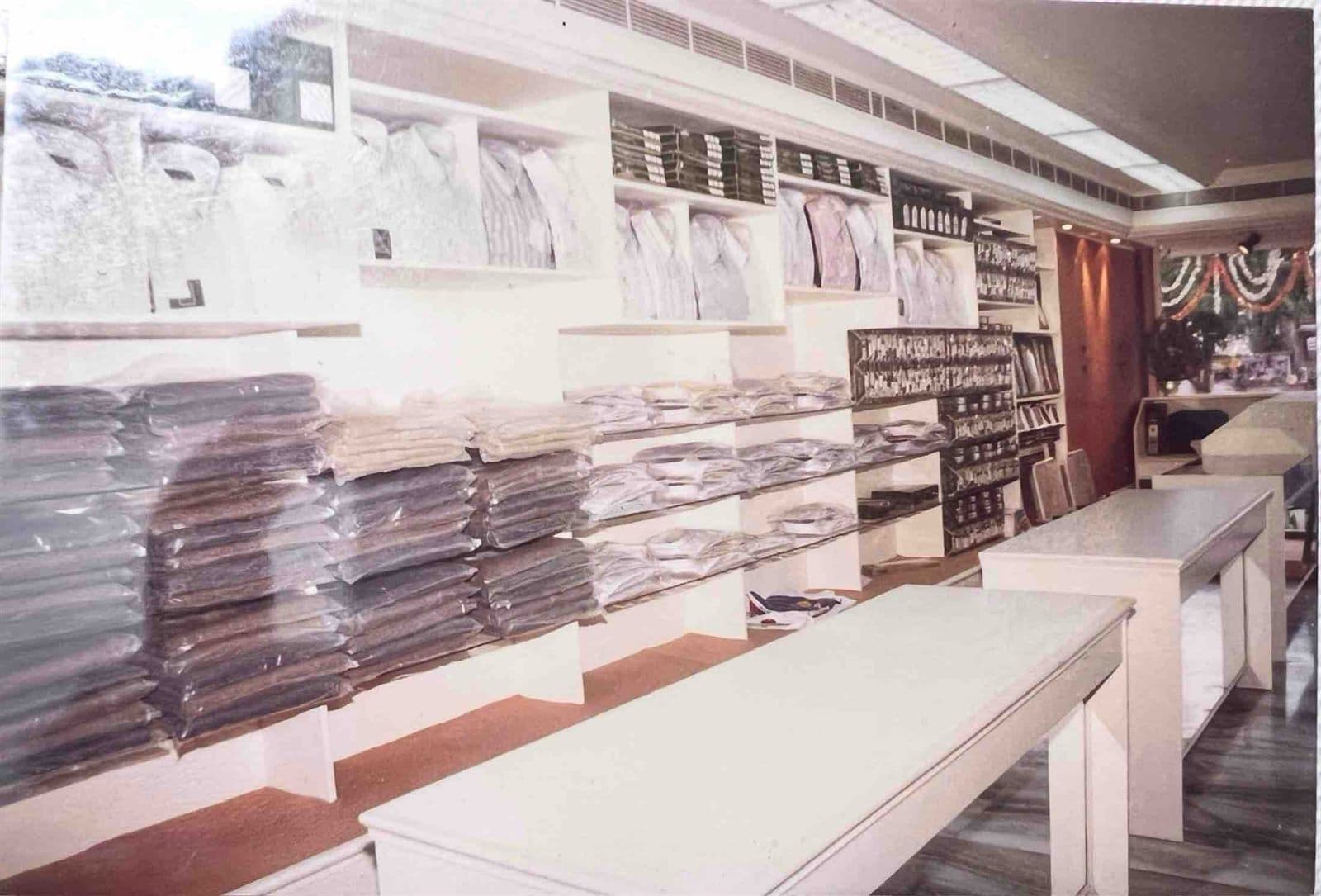 Modern Interior of the Exclusive Digjam Showroom (1990s) - Interior view of the exclusive Digjam showroom established by MF.Khan in Visakhapatnam, featuring bespoke suiting stacks and modern consultation counters. | MF.Khan Heritage Archives Visakhapatnam
